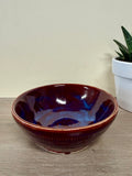 Thrown ceramic maroon bowl with blue highlights